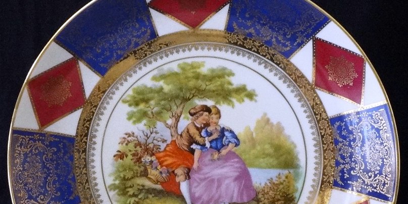Plate - Plato The center with a couple in a romantic scene and the border with red and blue colors, and with a size of 11 inches in diameter. En el centro con escena...